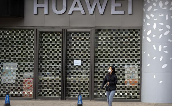 A woman wearing a face mask walks past a Huawei store temporarily closed due to coronavirus-related restrictions in Beijing, Thursday, May 12, 2022. China's leaders are struggling to reverse a deepening economic slump while keeping a "zero-COVID" strategy A woman wearing a face mask walks past a Huawei store temporarily closed due to coronavirus-related restrictions in Beijing, Thursday, May 12, 2022. China's leaders are struggling to reverse a deepening economic slump while keeping a "zero-COVID" strategy