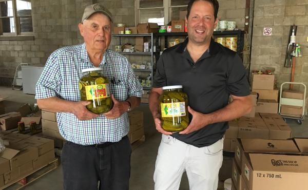 Don Woodbridge (left) and son Alan Woodbridge hold jars of pickles at their company in Harrow, Ontario. Orders are up in anticipation of retaliatory Canadian tariffs on U.S. gherkins. Don Woodbridge (left) and son Alan Woodbridge hold jars of pickles at their company in Harrow, Ontario. Orders are up in anticipation of retaliatory Canadian tariffs on U.S. gherkins.