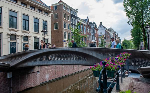 The almost 40-foot 3D-printed pedestrian bridge designed by Joris Laarman and built by Dutch robotics company MX3D has been opened in Amsterdam six years after the project was launched. The bridge, which was fabricated from stainless steel rods by six-axi The almost 40-foot 3D-printed pedestrian bridge designed by Joris Laarman and built by Dutch robotics company MX3D has been opened in Amsterdam six years after the project was launched. The bridge, which was fabricated from stainless steel rods by six-axi