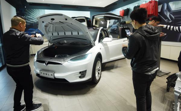 Customers look at Tesla cars at a showroom in Hangzhou in China's eastern Zhejiang province on April 4. The cut in Chinese auto import tariffs could help Tesla, which has been looking to break into the Chinese market. Customers look at Tesla cars at a showroom in Hangzhou in China's eastern Zhejiang province on April 4. The cut in Chinese auto import tariffs could help Tesla, which has been looking to break into the Chinese market.