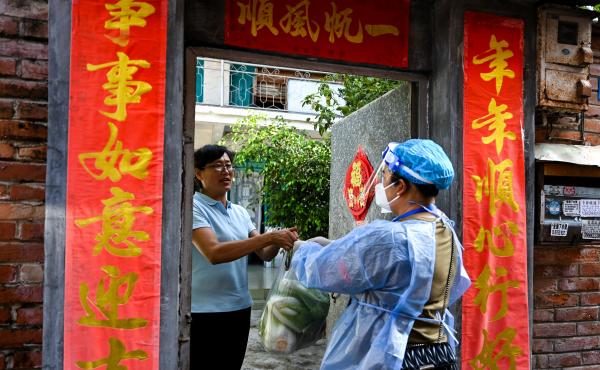 A community worker delivered daily necessities to a household in Ruili City in China's Yunnan Province during a July lockdown triggered by COVID cases. Ruili closed off its city proper and asked all residents to quarantine at home. Classes were suspended. A community worker delivered daily necessities to a household in Ruili City in China's Yunnan Province during a July lockdown triggered by COVID cases. Ruili closed off its city proper and asked all residents to quarantine at home. Classes were suspended.