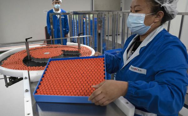 A worker feeds vials for production of a vaccine for COVID-19 at the SinoVac vaccine factory in Beijing. China said on Friday that it is joining the COVID-19 vaccine alliance known as COVAX. A worker feeds vials for production of a vaccine for COVID-19 at the SinoVac vaccine factory in Beijing. China said on Friday that it is joining the COVID-19 vaccine alliance known as COVAX.