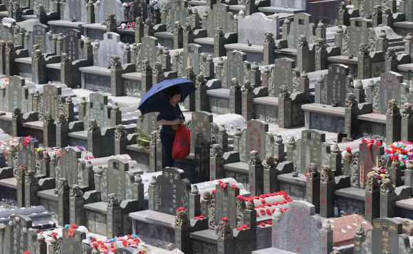 A mourner walks through a cemetery in Jinjiang during the Tomb-Sweeping Festival in 2015. A mourner walks through a cemetery in Jinjiang during the Tomb-Sweeping Festival in 2015.