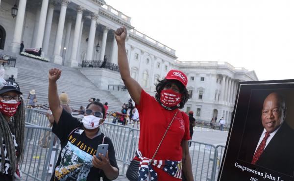 Members of the public wait in line to pay their respects to the flag-draped casket bearing the remains of Rep. John Lewis (D-GA) at the top of the East Front Steps of the U.S. Capitol. Members of the public wait in line to pay their respects to the flag-draped casket bearing the remains of Rep. John Lewis (D-GA) at the top of the East Front Steps of the U.S. Capitol.