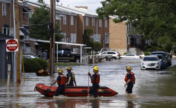 Philadelphia firefighters walk through a flooded neighborhood on Aug. 4, 2020, after Tropical Storm Isaias moved through. Philadelphia firefighters walk through a flooded neighborhood on Aug. 4, 2020, after Tropical Storm Isaias moved through.