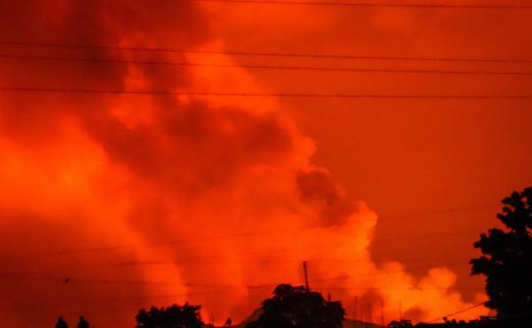 Two people are seen silhouetted against a night sky turned red by the eruption of Congo's Mount Nyiragongo on Saturday. Two people are seen silhouetted against a night sky turned red by the eruption of Congo's Mount Nyiragongo on Saturday.