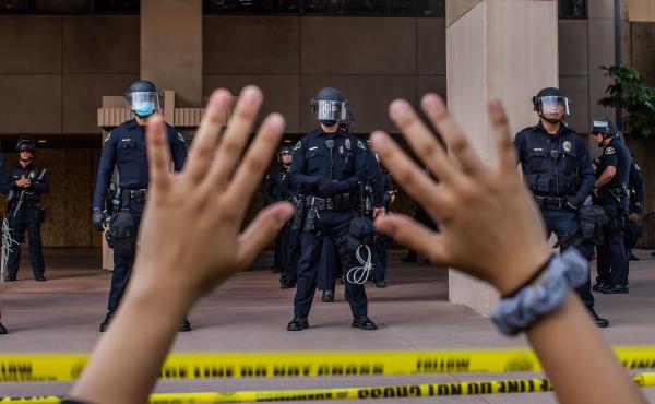 A demonstrator holds her hands up while she kneels in front of the Police at the Anaheim City Hall on June 1, 2020 in Anaheim, California. Reform pressures have many cops leaving the job. A demonstrator holds her hands up while she kneels in front of the Police at the Anaheim City Hall on June 1, 2020 in Anaheim, California. Reform pressures have many cops leaving the job.
