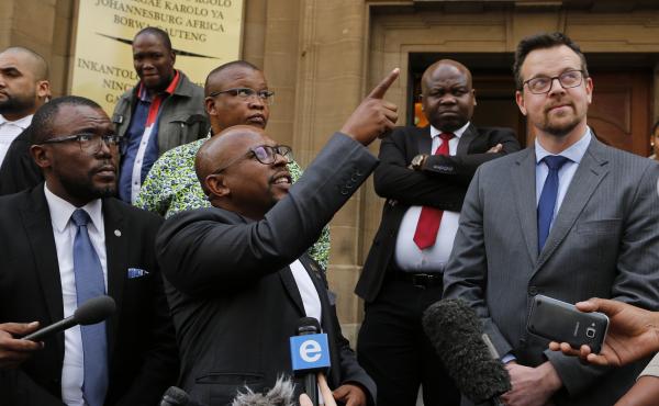 Nelson Mandela Foundation CEO Sello Hatang points to South Africa's current flag as he welcomes a ruling against its old flag in Johannesburg Wednesday. At right is Ernst Roets, leader of the AfriForum group that was targeted in the foundation's lawsuit. Nelson Mandela Foundation CEO Sello Hatang points to South Africa's current flag as he welcomes a ruling against its old flag in Johannesburg Wednesday. At right is Ernst Roets, leader of the AfriForum group that was targeted in the foundation's lawsuit.