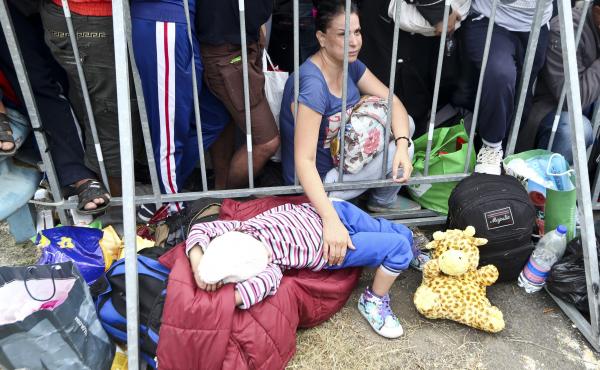 A migrant holds a child as they wait at the Croatia-Slovenia border crossing at Rigonce, Croatia, on Saturday. A migrant holds a child as they wait at the Croatia-Slovenia border crossing at Rigonce, Croatia, on Saturday.
