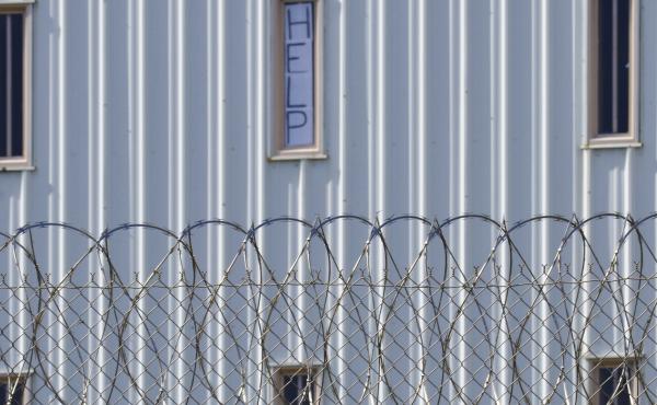 Holman Correctional Facility is one of the Alabama prisons that the Justice Department alleges inmates are subjected to excessive force by prison staff. This photo, taken in 2019, shows a sign that reads, "HELP," in the window of an inmate cell seen durin Holman Correctional Facility is one of the Alabama prisons that the Justice Department alleges inmates are subjected to excessive force by prison staff. This photo, taken in 2019, shows a sign that reads, "HELP," in the window of an inmate cell seen durin