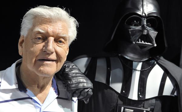 British actor David Prowse, who played Darth Vader in the first Star Wars trilogy, poses with a fan dressed in a Darth Vader costume during a Star Wars convention on April 27, 2013. On Sunday morning, Prowse's management company shared the news of his dea British actor David Prowse, who played Darth Vader in the first Star Wars trilogy, poses with a fan dressed in a Darth Vader costume during a Star Wars convention on April 27, 2013. On Sunday morning, Prowse's management company shared the news of his dea
