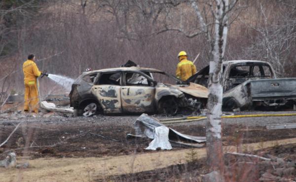 A volunteer firefighter douses hot spots near destroyed vehicles linked to the deadly weekend shooting rampage in Nova Scotia, on Monday. A volunteer firefighter douses hot spots near destroyed vehicles linked to the deadly weekend shooting rampage in Nova Scotia, on Monday.