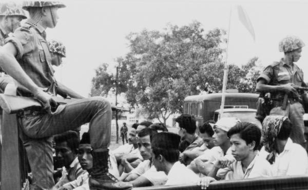 Indonesian soldiers stand guard over members of the youth wing of the Indonesian Communist Party, who were packed into a truck to be taken to a Jakarta prison in October 1965. Over the next few months, the government's military leadership carried out the Indonesian soldiers stand guard over members of the youth wing of the Indonesian Communist Party, who were packed into a truck to be taken to a Jakarta prison in October 1965. Over the next few months, the government's military leadership carried out the