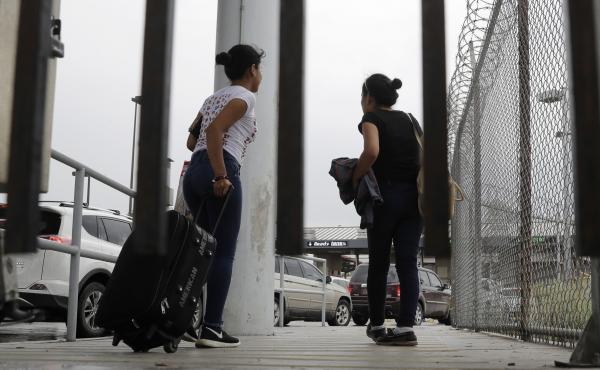 Sisters from Guatemala seeking asylum, cross a bridge to a port of entry in to the United States from Matamoros, Mexico, in Brownsville, Texas. Sisters from Guatemala seeking asylum, cross a bridge to a port of entry in to the United States from Matamoros, Mexico, in Brownsville, Texas.