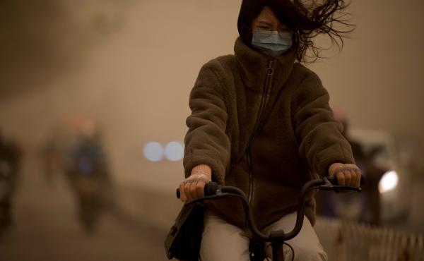 A woman cycles along a street during a sandstorm in Beijing on Monday. A woman cycles along a street during a sandstorm in Beijing on Monday.