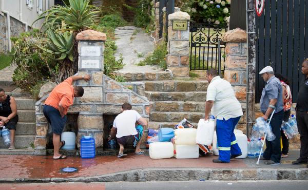 People collect drinking water from pipes fed by an underground spring last week in Cape Town. Next month, the city will slash its individual daily water consumption limit to 13.2 gallons, the mayor said, as the city battles its worst drought in a century. People collect drinking water from pipes fed by an underground spring last week in Cape Town. Next month, the city will slash its individual daily water consumption limit to 13.2 gallons, the mayor said, as the city battles its worst drought in a century.