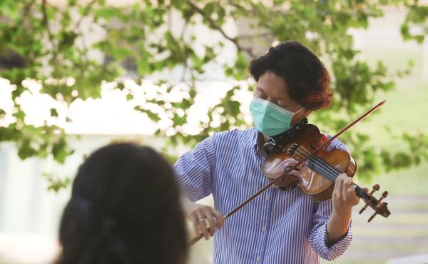 New York Philharmonic first violinist Kuan Cheng Lu, playing for a socially distanced audience of two at Lincoln Center on July 31. New York Philharmonic first violinist Kuan Cheng Lu, playing for a socially distanced audience of two at Lincoln Center on July 31.