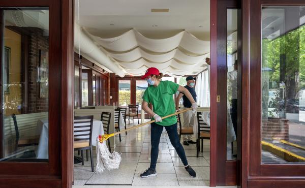 A cafe employee in Washington, D.C., cleans in preparation for reopening. A cafe employee in Washington, D.C., cleans in preparation for reopening.