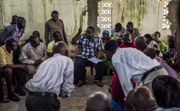 Dr. Mosoka Fallah (center), an epidemiologist who investigates cases of Ebola, meets with residents of New Kru Town, a district in Monrovia, Liberia. Dr. Mosoka Fallah (center), an epidemiologist who investigates cases of Ebola, meets with residents of New Kru Town, a district in Monrovia, Liberia.