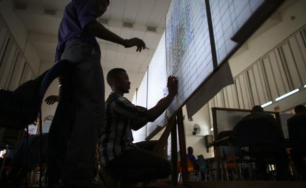 Workers add names to a mounting list of alerts at the emergency response center. Workers add names to a mounting list of alerts at the emergency response center.