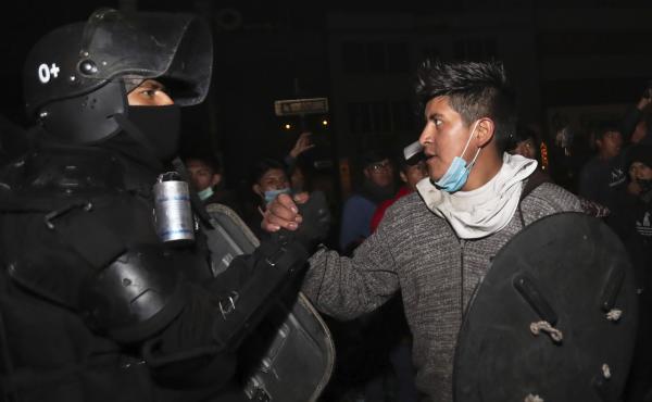 A protester shakes hands with a security officer in Quito, Ecuador, on Sunday as they celebrate the government's announcement that it has cancelled an austerity package. The package had triggered violent protests that paralyzed the economy and left seven A protester shakes hands with a security officer in Quito, Ecuador, on Sunday as they celebrate the government's announcement that it has cancelled an austerity package. The package had triggered violent protests that paralyzed the economy and left seven