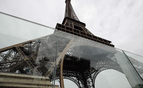 Newly installed panels of bulletproof glass surround two sides of the Eiffel Tower site in Paris. Construction is scheduled to be complete in July. Newly installed panels of bulletproof glass surround two sides of the Eiffel Tower site in Paris. Construction is scheduled to be complete in July.