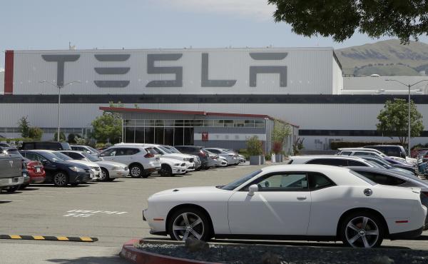 Vehicles are seen parked at the Tesla car plant in Fremont, Calif., on Monday. The parking lot was nearly full; Tesla resumed production in defiance of an order from county health authorities. Vehicles are seen parked at the Tesla car plant in Fremont, Calif., on Monday. The parking lot was nearly full; Tesla resumed production in defiance of an order from county health authorities.