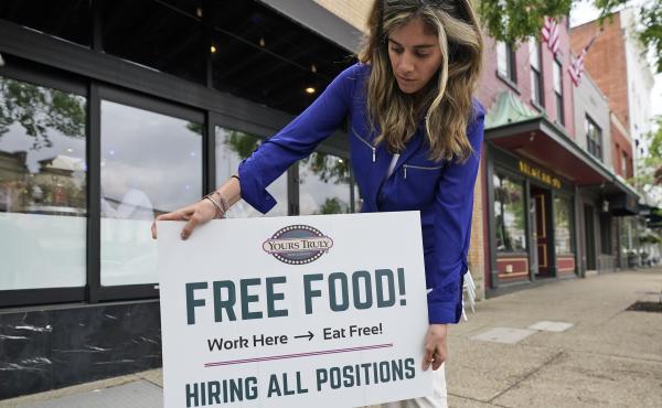 An employee at a restaurant in Chagrin Falls, Ohio, puts up a sign on June 3, 2021, looking for workers with the promise of free food for new hires. An employee at a restaurant in Chagrin Falls, Ohio, puts up a sign on June 3, 2021, looking for workers with the promise of free food for new hires.