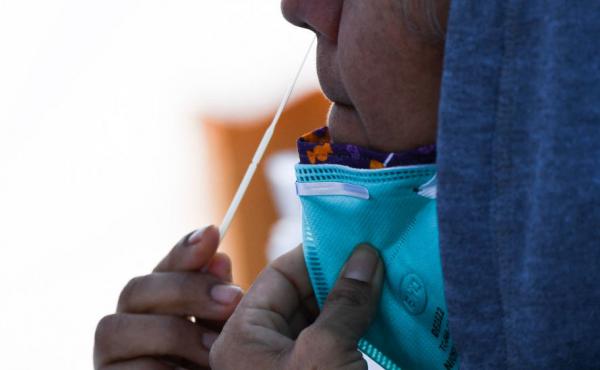 A person swabs their nose as they receive testing for both rapid antigen and PCR COVID-19 tests at a Reliant Health Services testing site in Hawthorne, Calif., on Jan. 18. A person swabs their nose as they receive testing for both rapid antigen and PCR COVID-19 tests at a Reliant Health Services testing site in Hawthorne, Calif., on Jan. 18.