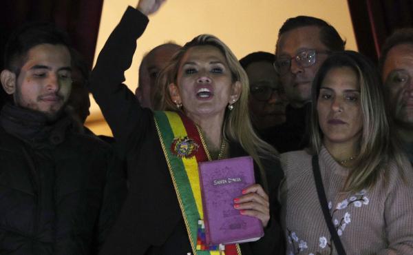 Jeanine Áñez, dressed in a presidential sash, addresses a crowd outside the president's residence in La Paz, Bolivia. The opposition politician declared herself interim president of the country Tuesday. Jeanine Áñez, dressed in a presidential sash, addresses a crowd outside the president's residence in La Paz, Bolivia. The opposition politician declared herself interim president of the country Tuesday.