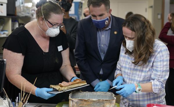 Virignia Gov. Ralph Northam ( center) watches as lead conservator for the Virginia Department of Historic Resources, Kate Ridgway (left) and Sue Donovon, conservator for Special Collections for the University of Virginia, remove the contents of a time cap Virignia Gov. Ralph Northam ( center) watches as lead conservator for the Virginia Department of Historic Resources, Kate Ridgway (left) and Sue Donovon, conservator for Special Collections for the University of Virginia, remove the contents of a time cap