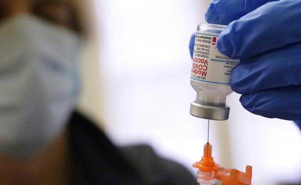 A booster dose of the Moderna COVID-19 vaccine is prepared during a vaccination clinic on Dec. 29 in Lawrence, Mass. The FDA is now shortening the wait time between the second dose and the booster to five months from six months. A booster dose of the Moderna COVID-19 vaccine is prepared during a vaccination clinic on Dec. 29 in Lawrence, Mass. The FDA is now shortening the wait time between the second dose and the booster to five months from six months.
