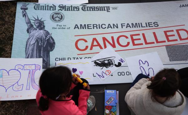 Children draw on top of a canceled check prop during a rally in favor of the child tax credit in front of the U.S. Capitol on Dec. 13, 2021, in Washington, D.C. Children draw on top of a canceled check prop during a rally in favor of the child tax credit in front of the U.S. Capitol on Dec. 13, 2021, in Washington, D.C.