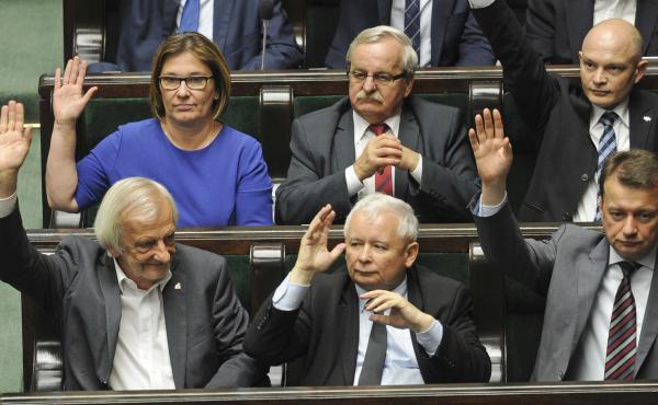 Law and Justice party leader Jaroslaw Kaczynski (bottom row center) and fellow party members vote Thursday to approve a law giving the president control over the Supreme Court. Law and Justice party leader Jaroslaw Kaczynski (bottom row center) and fellow party members vote Thursday to approve a law giving the president control over the Supreme Court.