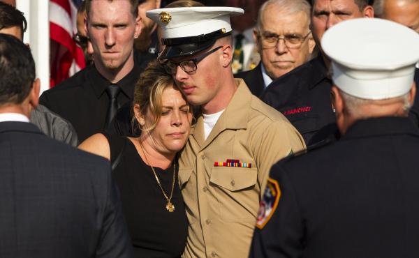 Erika Starke, left, is comforted by her son, Michael Haub, as they attend a second funeral service for New York Fire Department firefighter Michael Haub, in Franklin Square, N.Y. The New York City medical examiner identified more of his remains recovered Erika Starke, left, is comforted by her son, Michael Haub, as they attend a second funeral service for New York Fire Department firefighter Michael Haub, in Franklin Square, N.Y. The New York City medical examiner identified more of his remains recovered