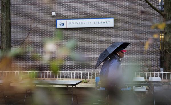A pedestrian walks by the library at the Georgia State University campus. A pedestrian walks by the library at the Georgia State University campus.