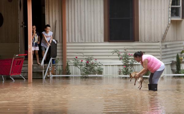 Alejandra Ventura lifts her dog out of the water after the Brazos River topped its banks and flooded a mobile home park in Richmond, Texas, on Tuesday. Alejandra Ventura lifts her dog out of the water after the Brazos River topped its banks and flooded a mobile home park in Richmond, Texas, on Tuesday.