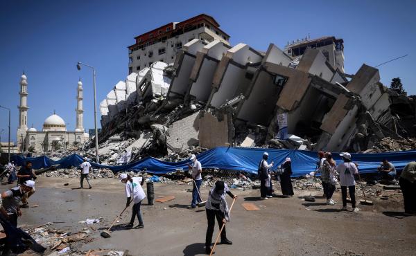 Palestinian volunteers and municipal workers clear the rubble of the Hanadi compound, recently destroyed by Israeli strikes, in Gaza City's Rimal district, on May 25, 2021. Palestinian volunteers and municipal workers clear the rubble of the Hanadi compound, recently destroyed by Israeli strikes, in Gaza City's Rimal district, on May 25, 2021.