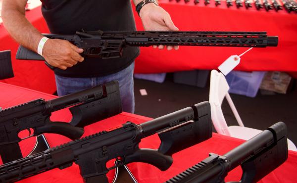 A clerk shows a customer an AR-15 style rifle at a gun show in Costa Mesa, Calif. in June 2021. Gun sales increased in the U.S, following COVID-19 pandemic lockdowns. A clerk shows a customer an AR-15 style rifle at a gun show in Costa Mesa, Calif. in June 2021. Gun sales increased in the U.S, following COVID-19 pandemic lockdowns.