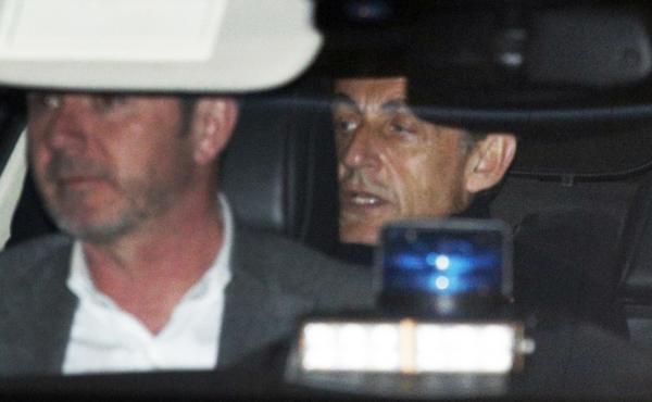 Former French President Nicolas Sarkozy, right, leaves the police station where he was held, in Nanterre, outside Paris, on Wednesday. Former French President Nicolas Sarkozy, right, leaves the police station where he was held, in Nanterre, outside Paris, on Wednesday.