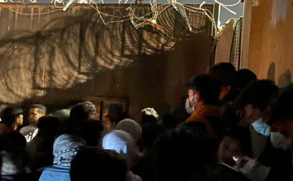 People waiting outside of a gate at the Kabul airport. People waiting outside of a gate at the Kabul airport.