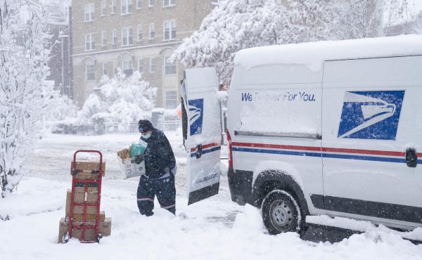 A postal worker carries packages through the snow on Jan. 3 in Washington, D.C. A postal worker carries packages through the snow on Jan. 3 in Washington, D.C.