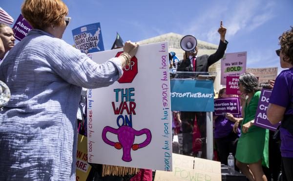 A pro-choice activist holds a sign as Sen. Cory Booker, a Democrat from New Jersey, speaks during a rally in front of the U.S. Supreme Court in May. A recent Gallup poll found that more Americans want less strict abortion laws. A pro-choice activist holds a sign as Sen. Cory Booker, a Democrat from New Jersey, speaks during a rally in front of the U.S. Supreme Court in May. A recent Gallup poll found that more Americans want less strict abortion laws.