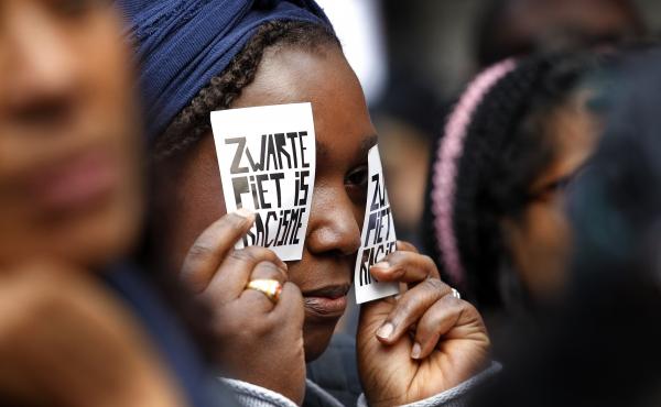 A demonstrator holds a sign reading "Black Pete Is Racism" during a 2013 demonstration in Amsterdam. Zwarte Piet or Black Pete is traditionally depicted by white people wearing blackface, Afro wigs and red lipstick. A demonstrator holds a sign reading "Black Pete Is Racism" during a 2013 demonstration in Amsterdam. Zwarte Piet or Black Pete is traditionally depicted by white people wearing blackface, Afro wigs and red lipstick.