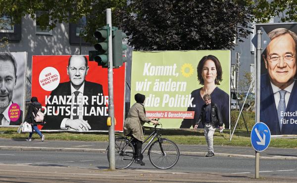 On Thursday, people in Gelsenkirchen, Germany, pass election posters of chancellor candidates Armin Laschet (from right) of the Christian Democratic Union, Annalena Baerbock of the Greens, Olaf Scholz of the Social Democratic Party and Christian Lindner o On Thursday, people in Gelsenkirchen, Germany, pass election posters of chancellor candidates Armin Laschet (from right) of the Christian Democratic Union, Annalena Baerbock of the Greens, Olaf Scholz of the Social Democratic Party and Christian Lindner o