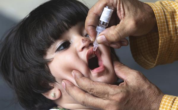 A health worker gives the oral polio vaccine to a child in Karachi, Pakistan. A health worker gives the oral polio vaccine to a child in Karachi, Pakistan.