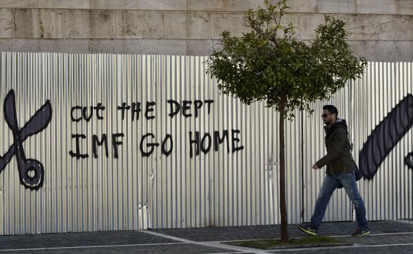 A man passes a graffiti in central Athens Friday, as Eurozone finance ministers consider Greece's request to extend the bailout loans that have kept its government afloat. A man passes a graffiti in central Athens Friday, as Eurozone finance ministers consider Greece's request to extend the bailout loans that have kept its government afloat.