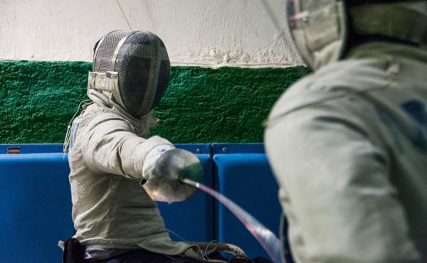 Panos Triantafyllou (left), in his fencing uniform and mask, trains with Vasilis Ntounis, his fellow Paralympic athlete and close friend. Panos Triantafyllou (left), in his fencing uniform and mask, trains with Vasilis Ntounis, his fellow Paralympic athlete and close friend.
