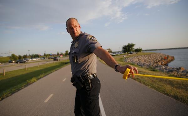 A policeman puts up crime scene tape around the scene of a shooting on the east side of Lake Hefner in Oklahoma City, Okla on Thursday. Police say an armed gunman injured three people at a restaurant before being shot dead by two armed civilians outside. A policeman puts up crime scene tape around the scene of a shooting on the east side of Lake Hefner in Oklahoma City, Okla on Thursday. Police say an armed gunman injured three people at a restaurant before being shot dead by two armed civilians outside.