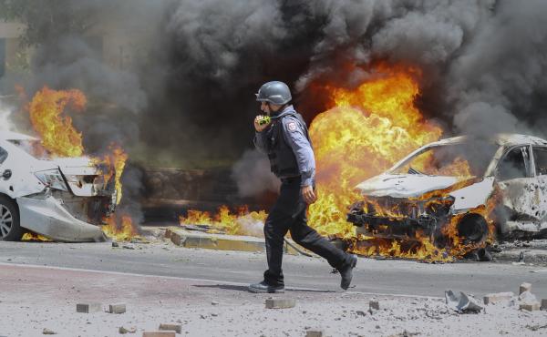 An Israeli firefighter walks next to cars hit by a rocket fired from Gaza on Tuesday in the southern Israeli city of Ashkelon. An Israeli firefighter walks next to cars hit by a rocket fired from Gaza on Tuesday in the southern Israeli city of Ashkelon.